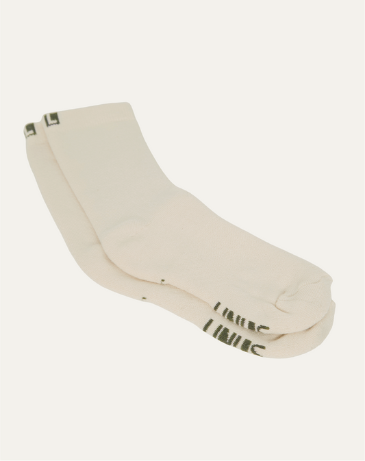 Par de meias de algodão off white baunilha. Fundo da imagem em cinza claro.