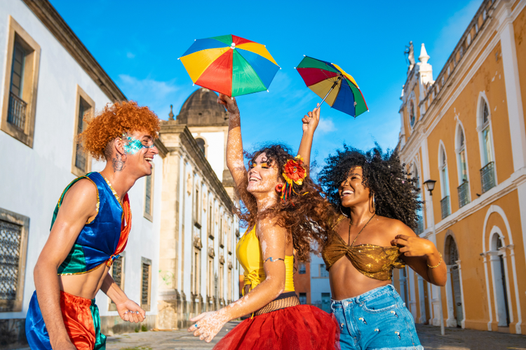 Grupo dançando e celebrando a folia com looks para Carnaval cheios de cor nas ruas da cidade