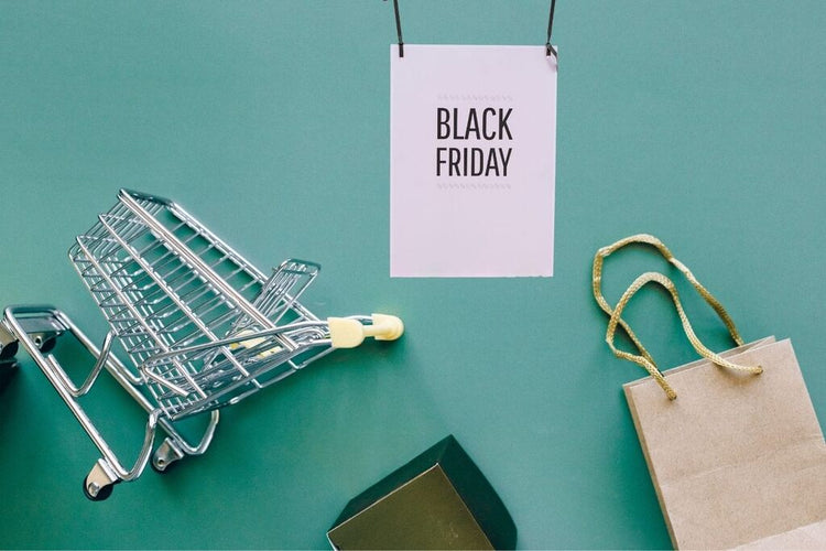 Carrinho de compras, sacola e cartão Black Friday sobre fundo verde, representando escolhas conscientes e consumo responsável.