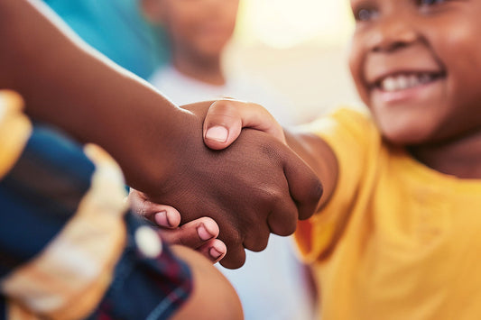 Adulto e criança dando as mãos.