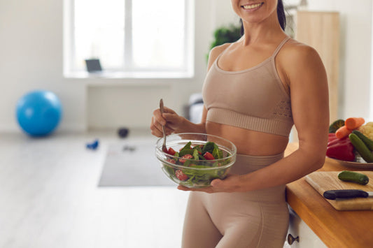 Mulher com tigela de salada almoçando.