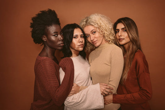 4 mulheres com diferentes etnias se abraçando.