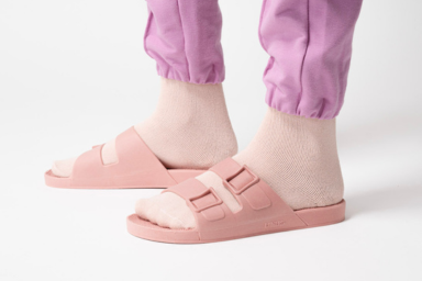Pés usando meia e sandália rosa bebê.