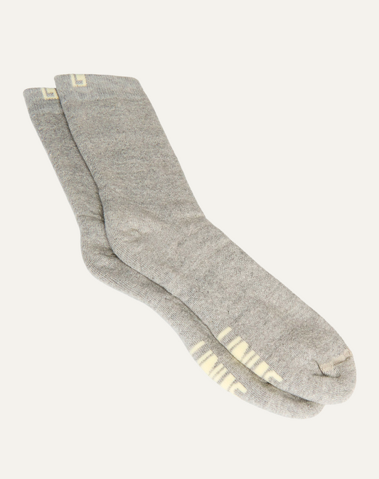 Par de meias de algodão cinza neblina. Fundo da imagem em cinza claro.