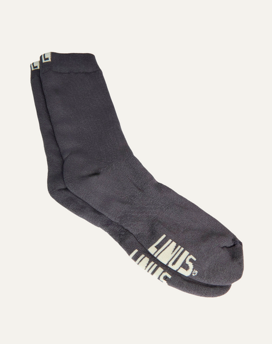 Par de meias de algodão cinza escuro grafite. Fundo da imagem em cinza claro.