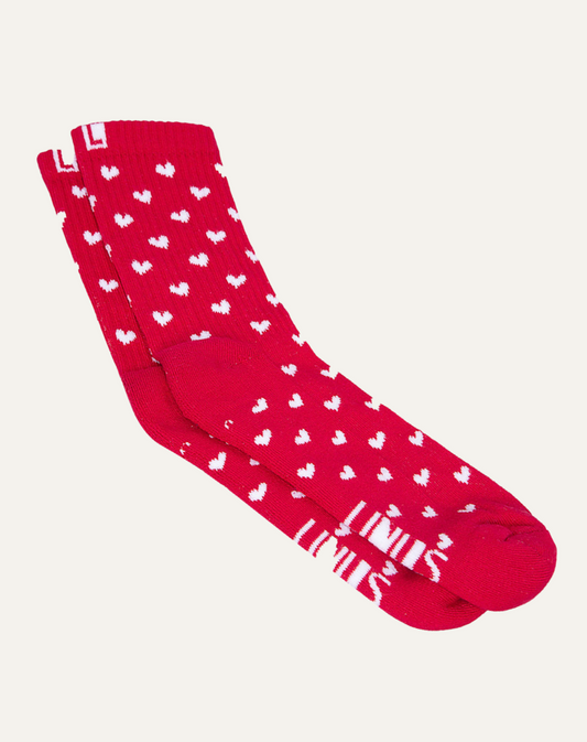 Par de meias de algodão com estampa de corações vermelho e branco em fundo cinza claro.